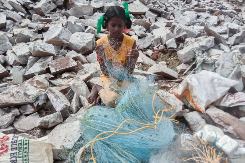 Kind einer Fischerfamilie bei der Kinderarbeit in Indien